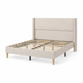 Cama de matrimonio tapizada en lino beige con estructura de madera